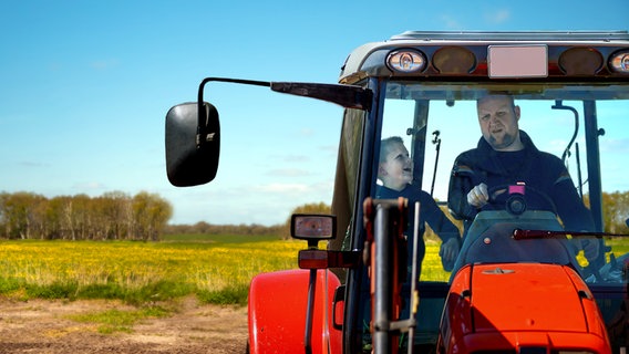 Mirko Lüthje sitzt mit seinem Sohn Piet auf einem Trecker. © Jörg Landsberg/Bremedia Produktion 