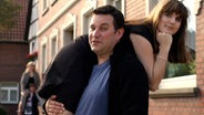 Ein Mann trägt eine über die Schulter gelegte Frau  