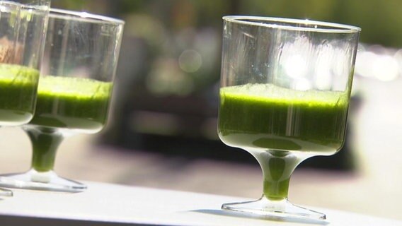 Gläser mit einem grünen Fruchtsaft.  