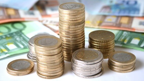 Euroscheine und Stapel von Euromünzen auf einem weißen Untergrund. © COLOURBOX Foto: fantazista