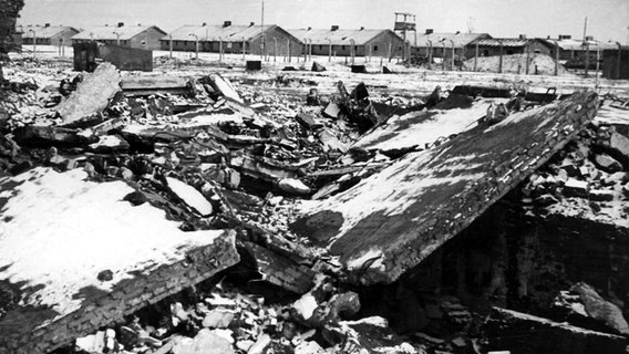 Schneebedeckter Schutt vor Zäunen und Baracken: Die Nazis hatten das Krematorium in Auschwitz-Birkenau vor der Befreiung durch die Rote Armee vernichtet. © picture-alliance/ dpa 