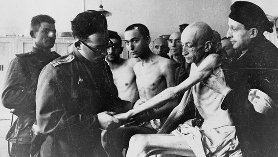 Ein sowjetischer Militärarzt untersucht kurz nach der Auschwitz-Befreiung einen bis auf die Knochen abgemagerten Häftling aus Wien. © picture alliance / akg-images Foto: akg-images