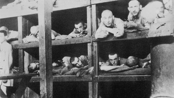 Ausgemergelte Männer liegen dicht an dicht in Holzkojen - Aufnahme von 1944 aus einer Gefangenen-Baracke in Auschwitz. © picture-alliance / Mary Evans Picture Library/WEIMA 