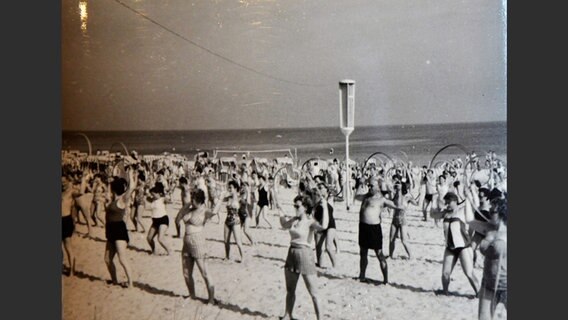 Menschen turnen in den 1950er-Jahren gemeinsam an einem Strand © Jürgen Kraft 