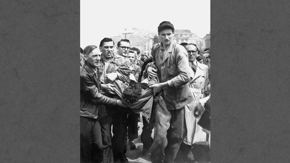 Demonstranten tragen am 17. Juni 1953 in Berlin einen Toten weg, der während des Volksaufstandes von einem sowjetischen Panzer getötet wurde. © picture-alliance / dpa 