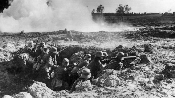 Deutsche Soldaten stehen im Ersten Weltkrieg in einem Schützengraben. © imago/United Archives 