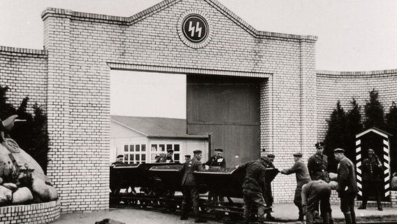 Häftlinge fahren an der Lagerstraße des KZ Esterwegen Loren aus dem Lager. Häftlinge fahren an der Lagerstraße des KZ Esterwegen Loren aus dem Lager. © Bundesarchiv Berlin Foto: Sohst, Kurzbein