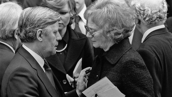 Helmut Schmidt spricht auf der Trauerfeier für den ermordeten Arbeitgeberpräsidenten Hanns Martin Schleyer mit dessen Witwe Waltrude Schleyer. Helmut Schmidt spricht auf der Trauerfeier für den ermordeten Arbeitgeberpräsidenten Hanns Martin Schleyer mit dessen Witwe Waltrude Schleyer. © dpa / picture-alliance Foto: Sven Simon