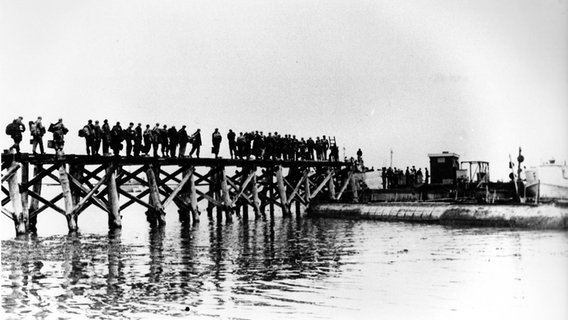 Soldaten gehen über eine Brücke auf ein Boot © Kirchspielarchiv Steinberg/Walter Schöppe Foto: Walter Schöppe