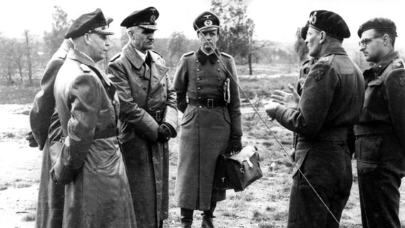 Der britische Feldmarschall Bernard Law Montgomery (2.v.r.) im Mai 1945 bei Lüneburg, während ihm eine deutsche Delegation unter Admiral Hans Georg von Friedeburg (l) die Übergabe der deutschen Truppen anbietet und um die Angabe der Bedingungen bittet. © dpa - Bildfunk 