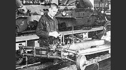 Werkhalle bei Volkswagen, Karosserie auf Band. Sowjetischer Kriegsgefangener (Zeichen "SU" auf Brust) am Band (Bild: dpa)  