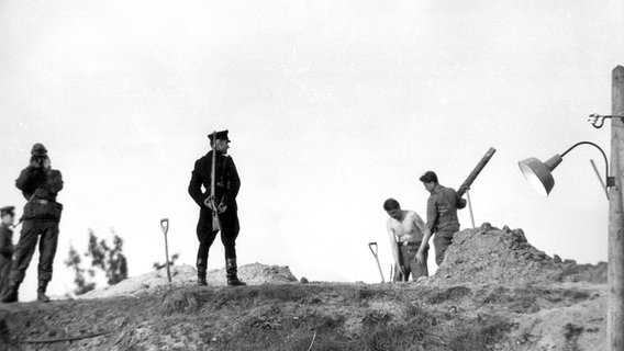 Am 9. Oktober 1961 errichten Bautrupps in Berlin unter Bewachung Fallgruben und Panzersperren. © picture-alliance / akg-images Foto: Gert Schuetz