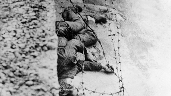 17. August 1962: Bei einem Fluchtversuch über die Mauer Nähe Friedrichstraße wird der 17-jährige Bauarbeiter Peter Fechter angeschossen. Weder West- noch Ostberliner Grenzpolizei greift ein. Fechter verblutet zwischen den Fronten. 17. August 1962: Bei einem Fluchtversuch über die Mauer Nähe Friedrichstraße wird der 17-jährige Bauarbeiter Peter Fechter angeschossen. Weder West- noch Ostberliner Grenzpolizei greift ein. Fechter verblutet zwischen den Fronten. © akg-images Foto: akg-images
