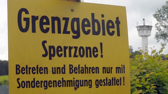 Warnschild an der DDR-Sperrzone mit Kontrollturm im Hintergrund © ZB - Fotoreport Foto: Jan-Peter Kasper