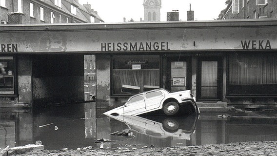 Angeschwemmter Fiat in der Fährstraße in Hamburg-Wilhelmsburg nach der Sturmflut 1962. © NDR Foto: Günther Hachmeister