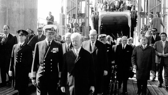 Der dänische König Frederik IX. (l) und Bundespräsident Dr. Heinrich Lübke (r) gehen am 14. Mai 1963 im dänischen Rodbyhavn an Bord des Fährschiffes "Kong Frederik IX". © picture-alliance / dpa 