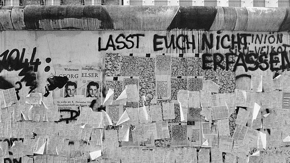 1987 kleben an der Berliner Mauer zahlreiche nicht ausgefüllte Fragebögen zur Volkszählung. © picture alliance / akg Foto: Henning Langenheim