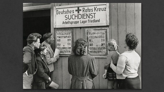 Menschen stehen vor Suchdienstplakate in Friedland. © Deutsches Rotes Kreuz 