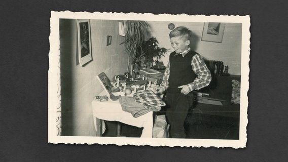Ein Junge blickt lächelnd auf einen Tisch mit Geschenken. © Stiftung Freilichtmuseum am Kiekeberg Foto: Privat