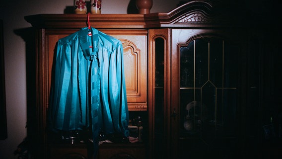 Die petrolfarbene Bluse von Helga K. hängt an ihrem braunen Wandschrank. © Hannes Wichmann Foto: Hannes Wichmann