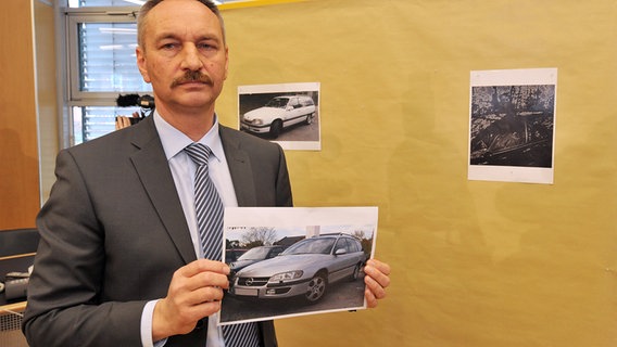 Der Leiter der SOKO Dennis, Martin Erftenbeck, mit Fotos des gesuchten Opel Omega Modells. © picture alliance / dpa Foto: Carmen Jaspersen