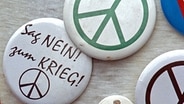 Button mit dem kreisförmigen Friedenssymbol. © picture-alliance / dpa Foto: Kay Nietfeld
