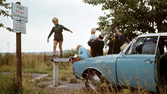 Eine Familie steht an der Grenze zwischen BRD und DDR bei Zorge im Harz und sieht auf die andere Seite. © picture-alliance/dpa 