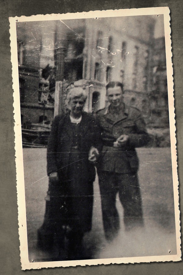 Herbert Klein (ein Opfer der Hamburger Wehrmachtjustiz) steht in einer Stadt neben seiner Mutter.  