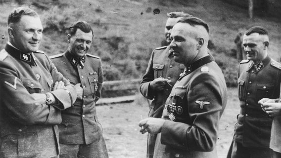 Rudolf Höß (vorne rechts) 1944 in einer Gruppe von SS-Offizieren (v.l.: Richard Baer, Josef Mengele, Josef Kramer, im Hintergrund rechts: unbekannt) in ihrer Freizeit in der Nähe von Auschwitz. © picture alliance / ASSOCIATED PRESS 