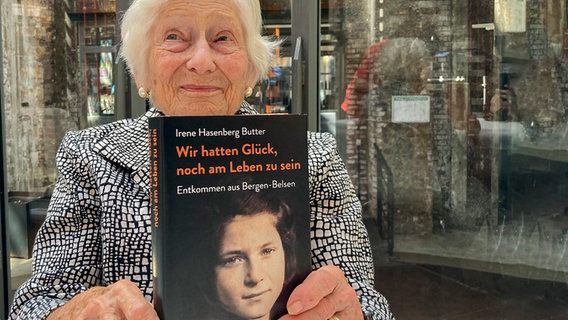 Irene Butter hält ihr Buch "Wir hatten Glück noch am Leben zu sein" hoch. © NDR / John Bidwell Foto: John Bidwell