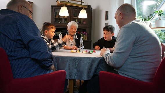 Ingeborg Illing aus Salzgitter mit ihrer Familie beim Spielen am Wohnzimmertisch. © NDR 