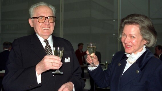 Rudolf Hell feiert am 19. Dezember 1991 in Kiel mit seiner Frau Jutta seinen 90. Geburtstag und hebt ein Glas Sekt in die Luft. © picture-alliance / dpa Foto: Wulf Pfeiffer
