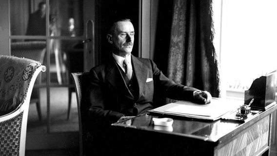 Thomas Mann sitzt an einem Schreibtisch in einem Brüsseler Hotel. © picture-alliance / KPA/TopFoto Foto: KPA