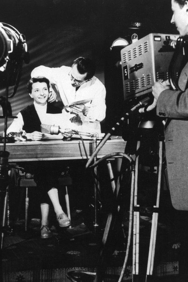 Die Ansagerin Irene Koss sitzt an einem Schreibtisch in einem Fernsehstudio. © NDR 