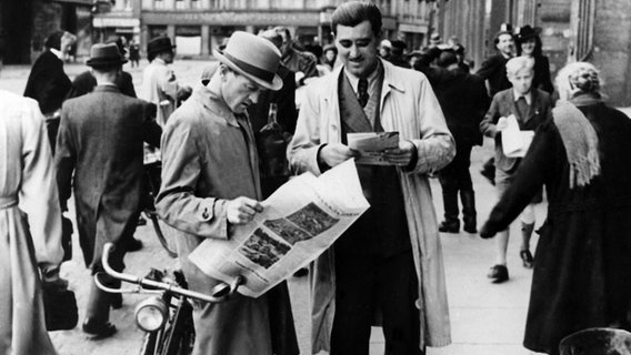 Zwei Männer lesen in der Nachkriegszeit auf der Straße eine Zeitung, undatierte Aufnahme. © picture alliance / dpa Foto: dpa