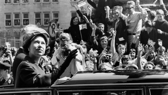Königin Elizabeth II. fährt am 28.05.1965, ihrem letzten Besuchstag in Deutschland, in einem offenen Wagen vom Hamburger Rathaus zum Jungfernstieg. © picture alliance / UPI dpa Foto: UPI