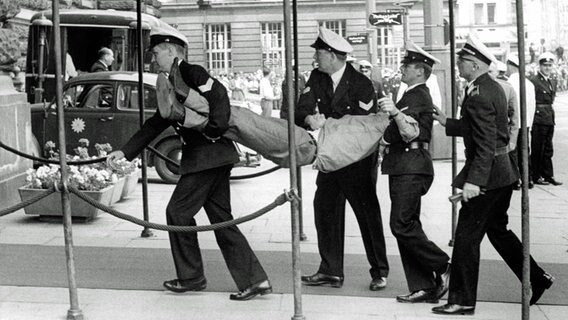 Polizisten tragen am 3. Juni 1967 auf dem Hamburger Rathausmarkt einen Teilnehmer der Demonstration gegen den Schah weg. Polizisten tragen am 3. Juni 1967 auf dem Hamburger Rathausmarkt einen Teilnehmer der Demonstration gegen den Schah weg. © picture-alliance / dpa