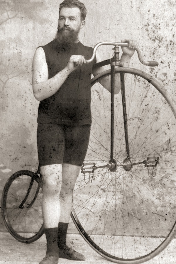 Der Radfahrer Paul Präsent posiert in einem Fotostudio neben seinem Hochrad. Der Radfahrer Paul Präsent posiert in einem Fotostudio neben seinem Hochrad. © RV Endspurt Hamburg