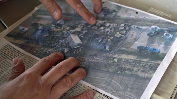 Auf einer Zeitung liegt eine Luftaufnahme vom Unfallort der Massenkarambolage auf der A 19 bei Kavelstorf am 8. April 2011. © NDR 