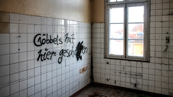 Auf die Fliesen der früheren Toilette der Villa Baltic in Kühlungsborn ist ein Graffiti gesprüht: "Göbbels hat hier geschissen". © NDR Foto: Daniel Sprenger