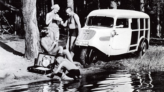 Familienausflug mit dem Tempo Hanseat: Zwei Männer, eine Frau und ein Kind picknicken 1951 an einem See. © Tempo / Daimler 