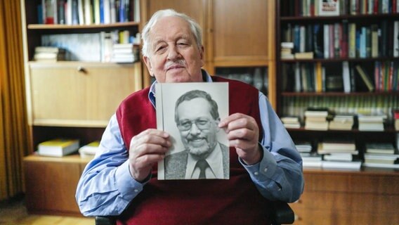 Journalist Uwe Bahnsen hält ein altes Foto von sich in den Händen. © NDR /jumpmedientv GmbH Foto: -