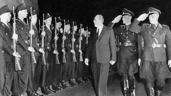 Der Ministerpräsident der DDR, Otto Grotewohl (3.v.r.), schreitet am 19. Oktober 1949 vor dem Schloss Niederschönhausen bei Berlin eine Ehrenkompanie der Volkspolizei ab, die anlässlich der Vereidigung des DDR-Kabinetts vor dem Gebäude angetreten ist. Der Ministerpräsident der DDR, Otto Grotewohl (3.v.r.), schreitet am 19. Oktober 1949 vor dem Schloss Niederschönhausen bei Berlin eine Ehrenkompanie der Volkspolizei ab, die anlässlich der Vereidigung des DDR-Kabinetts vor dem Gebäude angetreten ist. © picture-alliance / dpa | UPI