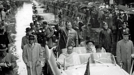 Willy Brandt (stehend) in einem offenen Wagen bei einer Fahrt durch die von Menschen gesäumten Straßen von New York 1959. © picture-alliance / dpa Foto: UPI