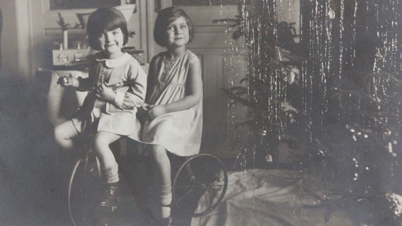 Eine alte Fotografie von Steffi Wittenberg und ihre Cousine als Kinder in einer Hamburger Wohnung zur Weihnachtszeit.  