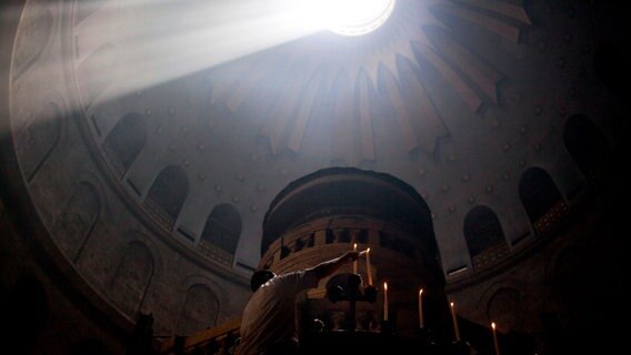 Ein Lichtkegel fällt von oben in die Grabeskirche in Jerusalem. © picture alliance / AP Photo | Sebastian Scheiner Foto: Sebastian Scheiner