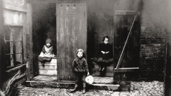 Kinder sitzen auf Plumsklos in einem Hamburger Hinterhof © Staatsarchiv 