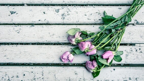 Verwelkte Rosen auf einer Bank. © photocase.de Foto: rowan