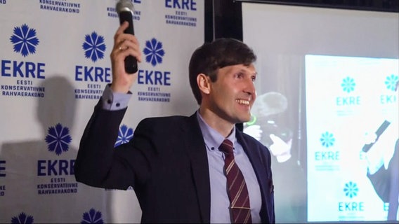 Estlands Finanzminister Martin Helme von EKRE steht auf einer Bühne und hält ein Mikrofon in der Hand. © NDR Foto: Screenshot