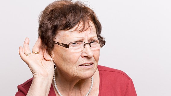 Eine ältere Dame mit skeptischen Gesichtsausdruck hält eine Hand zum Lauschen hinter ihr rechtes Ohr. © fotolia.com Foto: DDRockstar